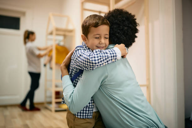 istock Affectionate small boy embracing his black mother on first day at kindergarten. 1369912971