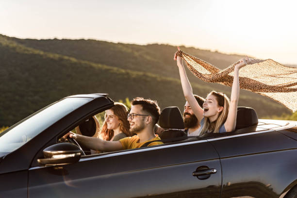istock Young happy couples going on a road trip by convertible car. 1369913135