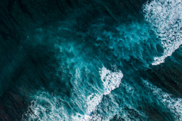 istock Big ocean waves hitting a coral reef. View from above. 1369913972