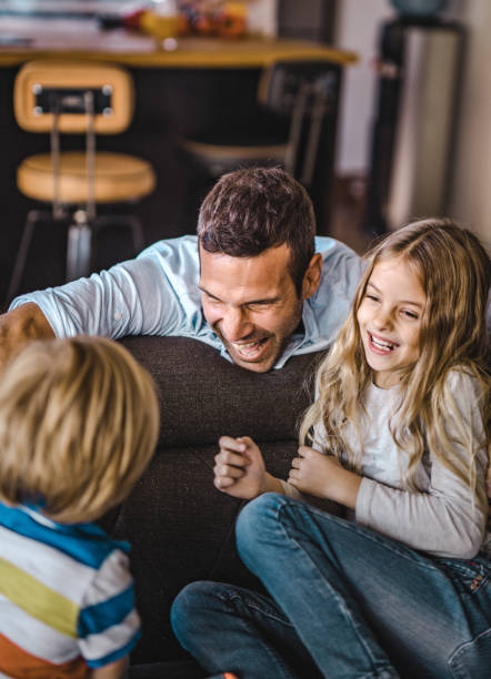 istock Happy father having fun while talking to his kids at home. 1369914126