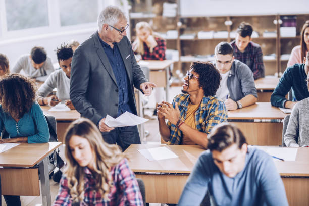 istock Happy black student talking to a professor in the classroom. 1369916020