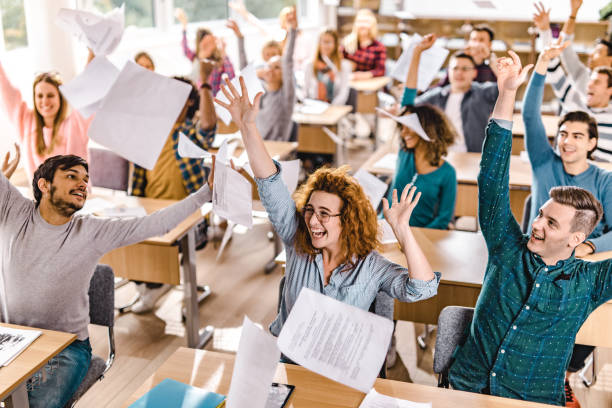 istock Large group of cheerful students having fun while celebrating the end of a class in the classroom. 1369916719