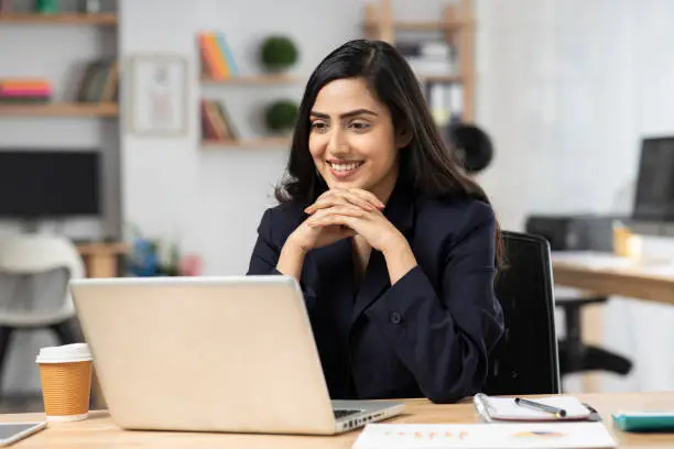 Photo of young woman in office working on laptop. stock photo