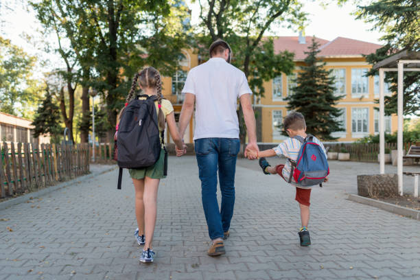istock Father and two kids going to school 1369917293