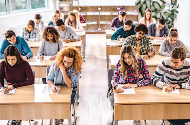 istock Large group of students writing an exam in the classroom. 1369917509
