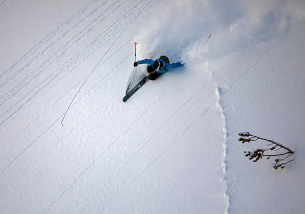 Freeride skier making a powerful turn in powder snow