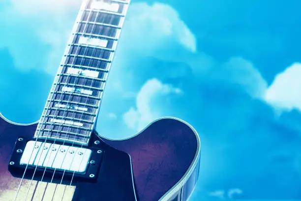 Photo of Semi-acoustic electric guitar against a cloudy sky