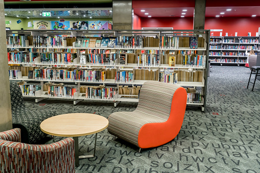 Library corridor of bookshelves - selective lighting and focus.