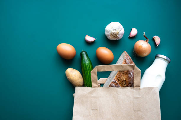 istock A paper shopping bag with fresh vegetables, bread, a milk bottle and eggs 1369919656