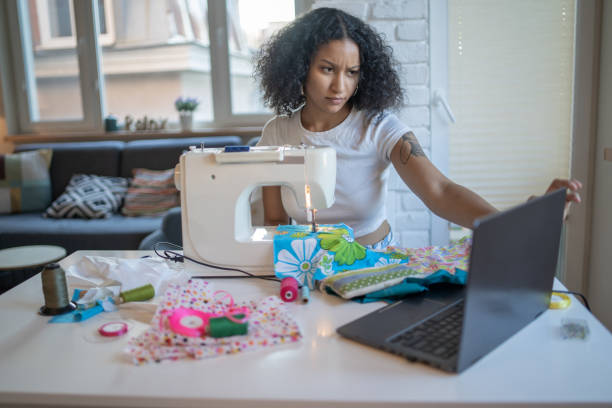 istock Frowning seamstress looking at laptop 1369920458