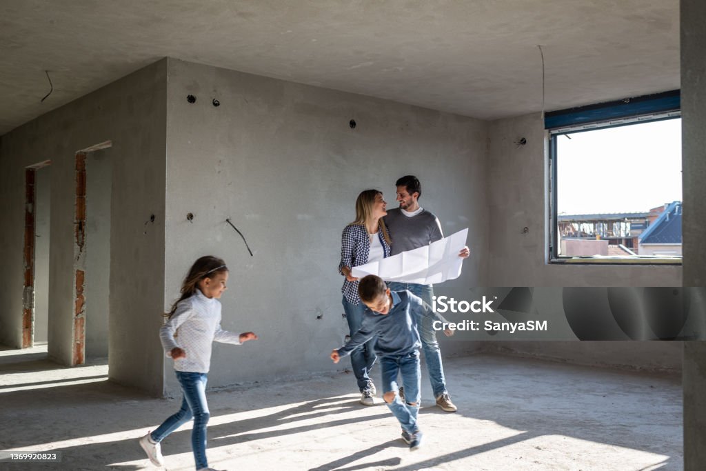 Glückliche Familie analysiert Pläne in ihrer neuen Wohnung - Lizenzfrei Familie Stock-Foto