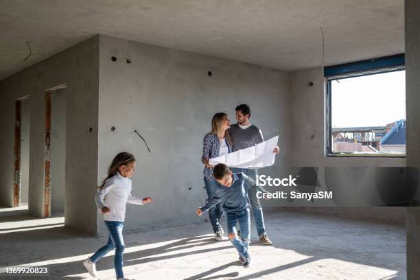 Glückliche Familie Analysiert Pläne In Ihrer Neuen Wohnung Stockfoto und mehr Bilder von Familie