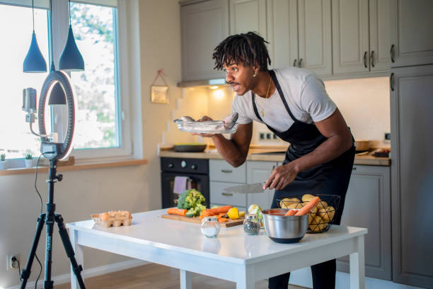 A male vlogger showing a fresh fish to the camera