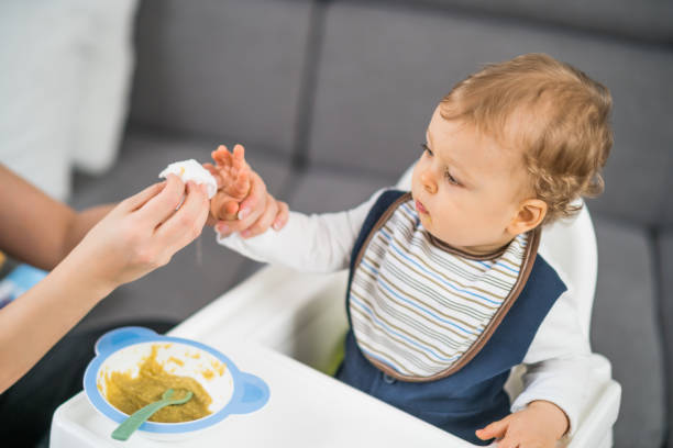 Cute baby boy got dirty while eating stock photo