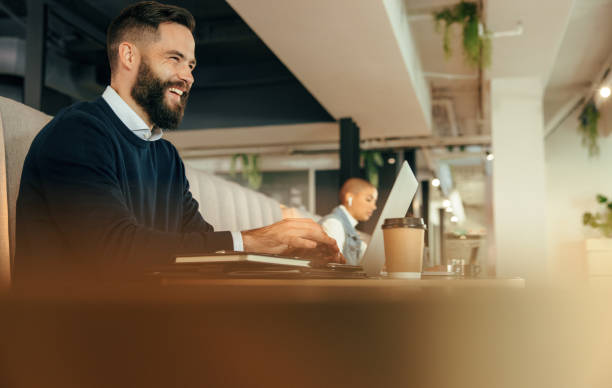 istock Happy young businessman working on his laptop 1369923956