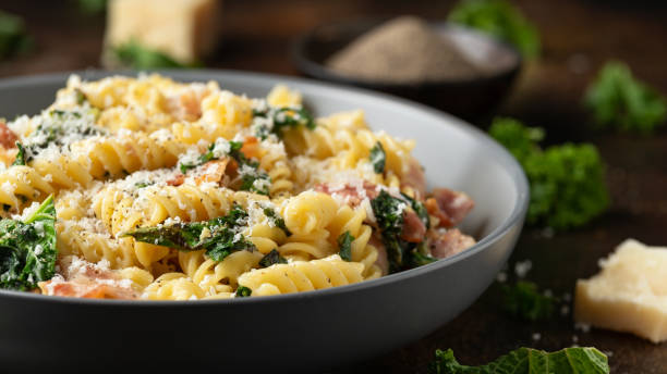 pasta fusilli con tocino, col rizada y queso parmesano. alimentación saludable - pancetta fotografías e imágenes de stock