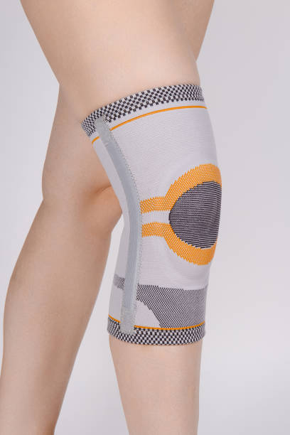 istock Knee Support Brace on leg isolated on white background. Elastic orthopedic orthosis. Anatomic braces for knee fixation, injuries and pain. Protective knee joint bandage sleeve. Trauma, rehabilitation 1369932944