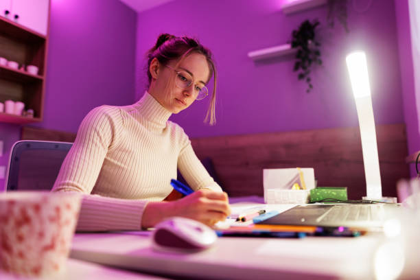 teenage girl studying for school in her room - note rose image saturated color imagens e fotografias de stock