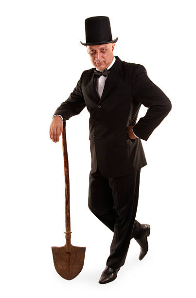 Gravedigger is standing with dirty spade This is a spooky mortician, grave digger. grave digger stock pictures, royalty-free photos & images