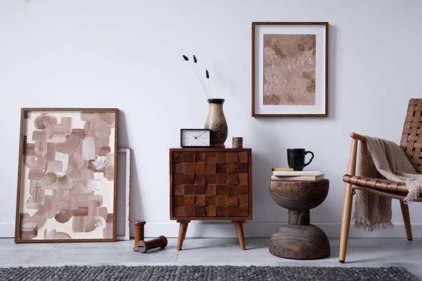 istock Stylish living room interior design with small wooden commode, mock up poster frame and creative accessories and home decor. Modern home staging. Template. Copy space. 