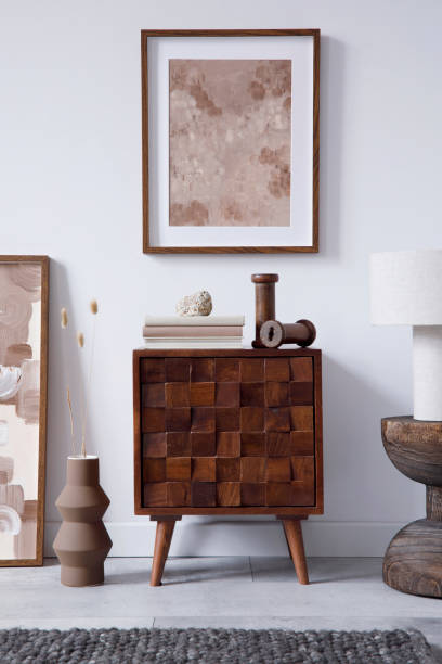 istock Creative living room interior design with wooden commode, mock up frame and vintage accessories in modern home decor. Home staging. Template. Copy space. 1369937746