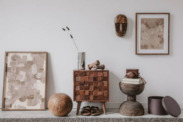 istock Stylish living room interior design with small wooden commode, mock up poster frame and creative accessories and home decor. Modern home staging. Template. Copy space. 