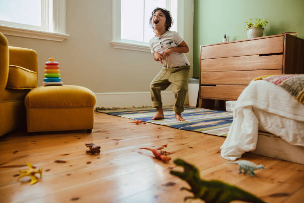 istock Creative young boy mimicking a t-rex dinosaur in his play area 1369938820