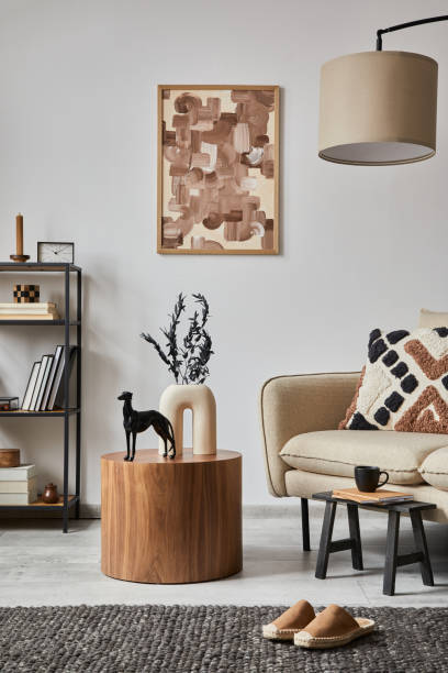 istock Modern living room interior composition with mock up poster frame, beige sofa, wooden side table and small home decorations. Creative home staging. White wall. Copy space. Template. 1369939019