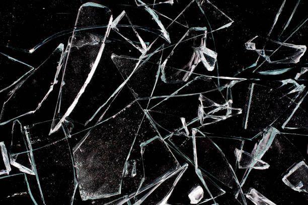 istock Shards of broken window glass on a black background. 1369939062
