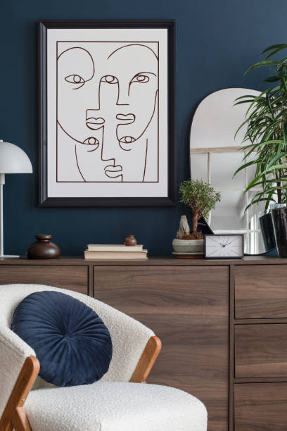 istock Modern living room interior composition with mock up poster frame, armchair, wooden commode and modern home accessories. Blue wall. Template. Copy space. Home staging. 1369939314