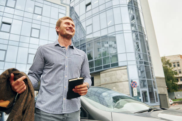 istock With notepad in hand. Man having a walk outdoors in the city at daytime 1369939412