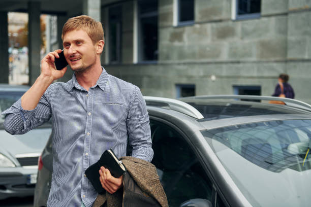 istock Talking by phone. Man having a walk outdoors in the city at daytime 1369939926