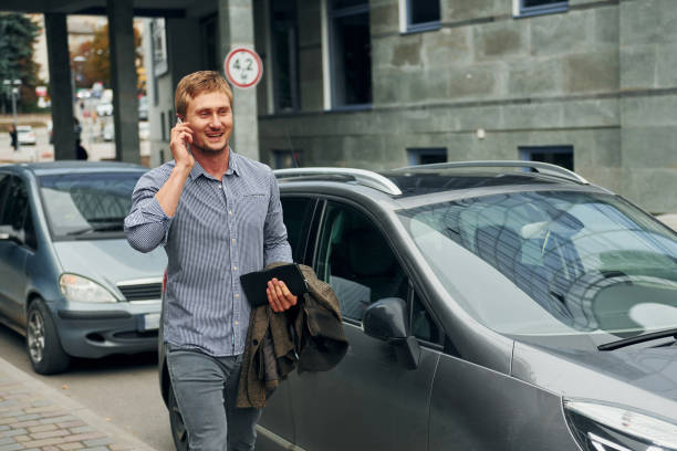 istock Talking by phone. Man having a walk outdoors in the city at daytime 1369939937