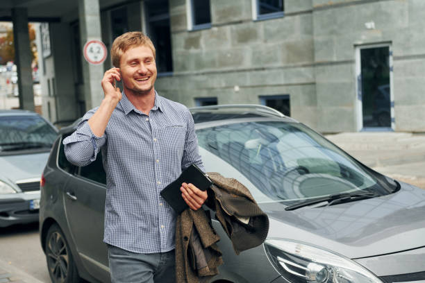 istock Talking by phone. Man having a walk outdoors in the city at daytime 1369939938