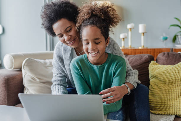 istock Mother and daughter using laptop at home 1369941876