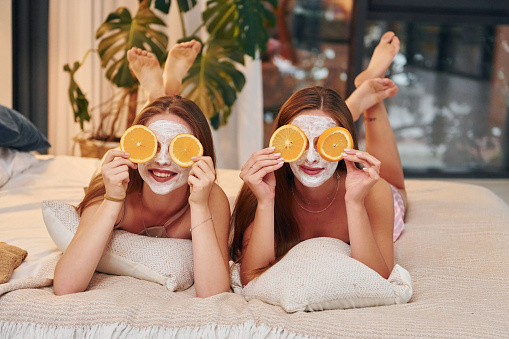 White clearing mask on faces. Two happy women is at a bachelorette party together.