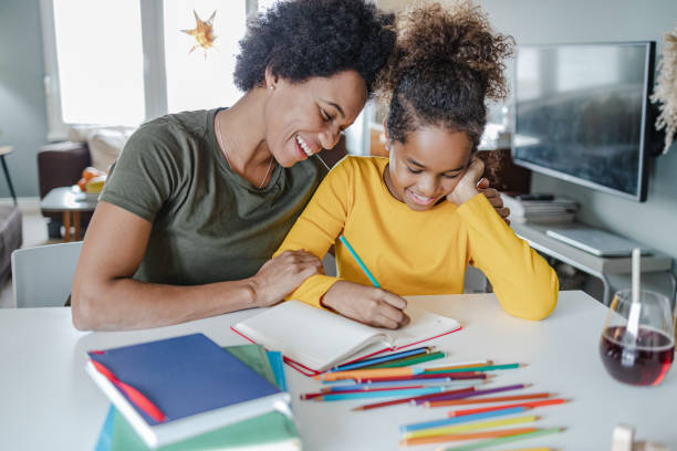 istock Caring mother assists her daughter in writing homework 1369942236