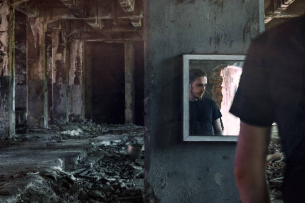 Young man portrait reflected in mirror in abandoned place