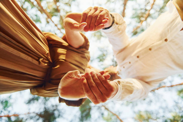 istock View from below. Happy couple is outdoors in the forest at daytime 1369943830