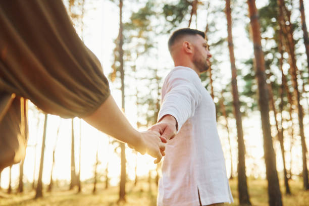 istock Having a walk. Happy couple is outdoors in the forest at daytime 1369944598
