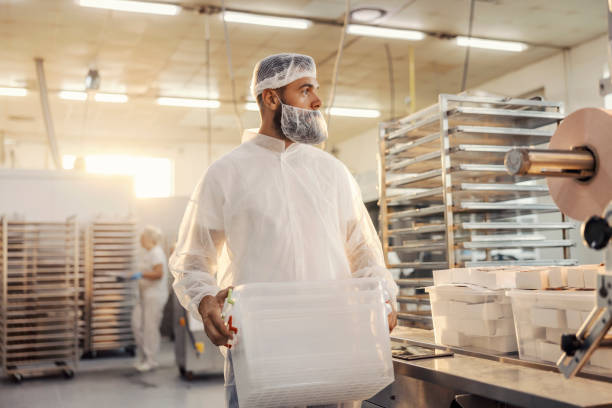 istock A food factory worker carry plastic containers. 1369944605