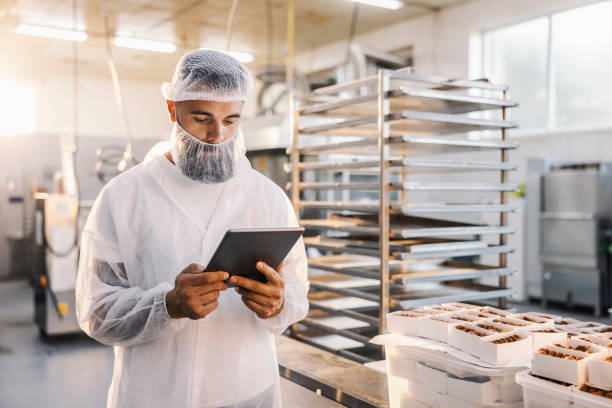 istock A food factory worker using tablet and checking on cookies. 1369944655