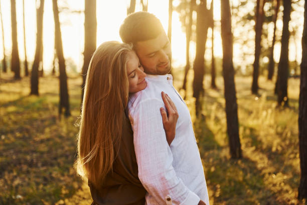 istock Illuminated by sunlight. Happy couple is outdoors in the forest at daytime 1369944744