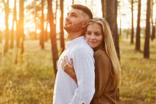 istock Illuminated by sunlight. Happy couple is outdoors in the forest at daytime 1369944746
