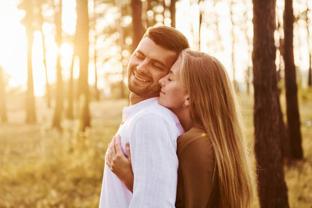 istock Illuminated by sunlight. Happy couple is outdoors in the forest at daytime 1369944759