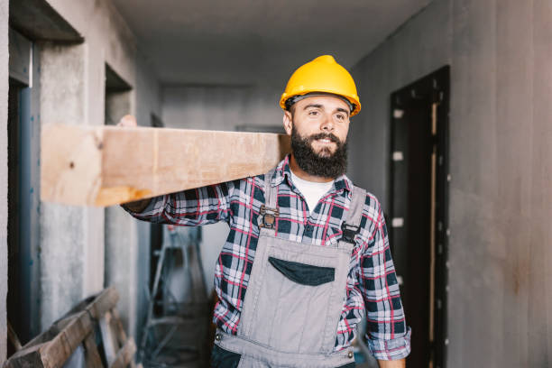 A handyman relocating wooden beam in a building in construction process. stock photo