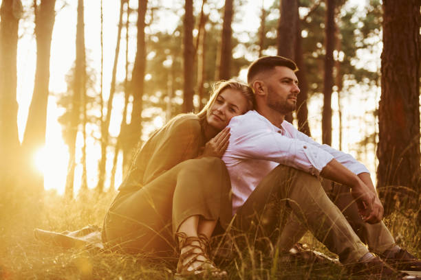 istock Resting in the forest. Happy couple is outdoors at daytime 1369945234