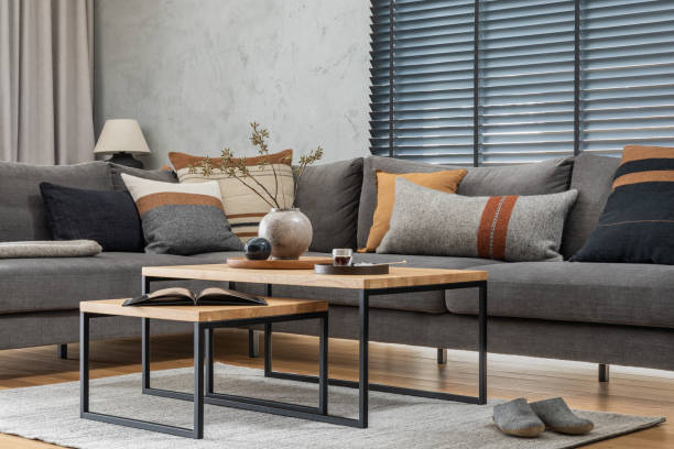 istock Creative composition of elegant living room interior with grey corner sofa, coffee table and stylish personal accessories. Modern home decor. Panoramic windows. Template. 1369945804