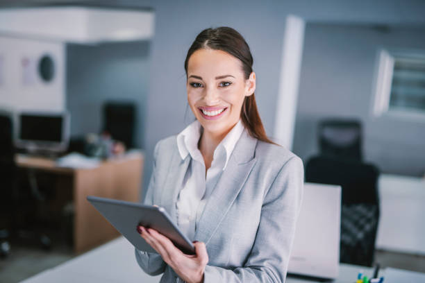 istock A happy businesswoman using tablet for work at office and smiling at camera. 1369947225