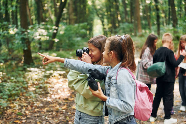 istock Looking for a path. Kids in green forest at summer daytime together 1369949557